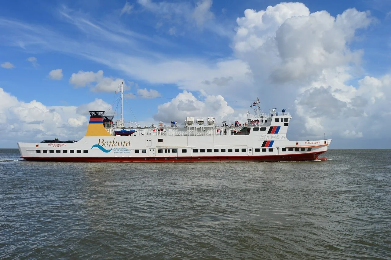 Eine Autofähre der AG EMS auf der Überfahrt. Man erkennt Passagiere auf dem Oberdeck.
